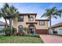 Charming two-story home featuring lush landscaping, a red brick driveway, and an attached two-car garage at 5807 Cay Cove Ct, Tampa, FL 33615