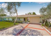 Charming single-story home with a well-manicured lawn and a spacious driveway leading to an attached garage at 762 Marjon Ave, Dunedin, FL 34698