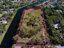 Expansive waterfront property featuring mature trees and a private home, bordered by a waterway offering serene views at 9554 90Th Ave, Seminole, FL 33777