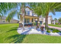 Charming two-story home with a well-manicured lawn and beautiful landscaping at 10072 Sage Creek Dr, Ruskin, FL 33573
