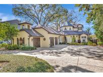 Elegant home features a charming exterior with a turret, attached garage, and driveway, all set amidst lush landscaping at 1108 W Charter St, Tampa, FL 33602