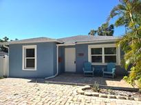 Charming blue single-story home with brick driveway and inviting front porch seating area at 4500 23Rd S Ave, St Petersburg, FL 33711