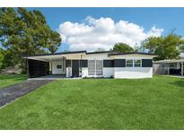 Charming single-story home with black and white accent paint and a lush green lawn at 5108 Tangelo Dr, New Port Richey, FL 34652