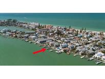 Stunning coastal home on stilts with a private dock and boats along a tranquil waterfront at 8685 E Bay Dr, Treasure Island, FL 33706