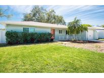 Charming single-story home with a well-manicured lawn, tropical landscaping, and a quaint front patio at 10864 90Th Ter, Seminole, FL 33772