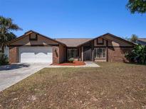 Charming single Gathering home with brick and siding, a well-maintained lawn and a two-car garage at 2412 Arborwood Dr, Valrico, FL 33596