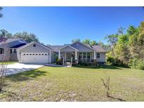 Charming home with a well-maintained lawn, attached garage and inviting front porch at 37362 Dixie Ave, Dade City, FL 33525