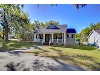 Charming two-story home with a welcoming front porch and mature landscaping, perfect for relaxing and enjoying the outdoors at 37410 Dixie Ave, Dade City, FL 33525