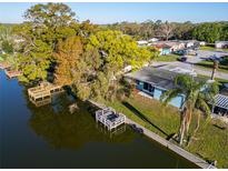Aerial view of a waterfront single-Gathering home with mature trees and boat dock at 3814 Sunray Dr, Holiday, FL 34691