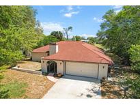 Charming home featuring a well-maintained lawn, two-car garage and a welcoming front entrance at 5140 Kirkwood Ave, Spring Hill, FL 34608