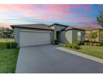 Charming single-story home with a two-car garage, well-maintained lawn, and inviting curb appeal under a colorful sky at 6727 Bar S Bar Trail, Zephyrhills, FL 33541