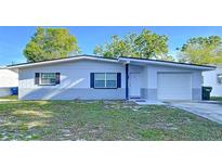 Charming single-story home featuring a manicured front yard and attached garage at 910 Lakeside Dr, Largo, FL 33778