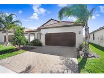 Charming single-story home featuring a tile roof, a two-car garage, and beautifully maintained landscaping at 17214 Star Banks St, Wimauma, FL 33598