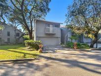 Charming two-story home with a front yard, garage and a small balcony under clear blue skies at 2011 Arbor Dr, Clearwater, FL 33760