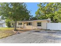 Charming single-story home featuring a brick entryway, neutral paint, and mature trees at 230 Davison Ne Ave, St Petersburg, FL 33703