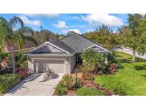 Charming single-story home with a well-manicured lawn and an attached two-car garage at 4811 Forest Creek Trl, Parrish, FL 34219