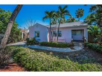 Charming pink single story home with tidy landscaping and sidewalk entry, accented by palm trees at 805 Bruce Ave, Clearwater Beach, FL 33767