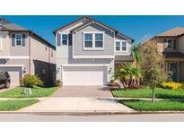 Charming two-story home with a brick driveway, two-car garage, and well-maintained landscaping at 8609 Winning Fields Rd, New Port Richey, FL 34655
