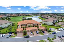 Beautiful condo community with lush landscaping, serene lake, and manicured golf course views at 13823 Messina Loop # 204, Bradenton, FL 34211