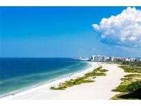 Scenic beach view showcasing white sand, clear water, and modern buildings against a blue sky at 1390 Gulf Blvd # Ph 2, Clearwater Beach, FL 33767