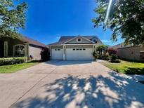 Charming single-story home with a three-car garage and a well-maintained lawn and landscape at 16313 Bridgecrossing Dr, Lithia, FL 33547