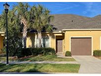 Charming townhome featuring a well-maintained lawn, palm trees, and a single-car garage at 1706 Trailwater St, Ruskin, FL 33570