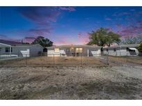 Charming single-story home with a fenced yard under a beautiful sunset sky at 2533 Limewood Dr, Holiday, FL 34690