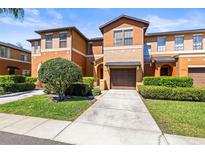 Two-story townhouse features a one car garage and landscaped front yard at 30103 Mossbank Dr, Wesley Chapel, FL 33543