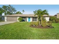 Charming single-story home with a well-manicured lawn and a bright blue front door at 4065 38Th S St, St Petersburg, FL 33711