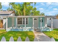 Charming home featuring a quaint front porch, seating area, and fresh exterior paint at 4803 N 9Th St, Tampa, FL 33603