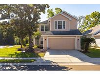 Charming two-story home with a two car garage and well maintained front yard with mature trees at 5167 Sterling Manor Dr, Tampa, FL 33647