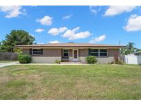 Charming single-story home with a well-maintained lawn and welcoming front entrance and brick facade at 1542 Picardy Cir, Clearwater, FL 33755