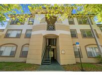 Exterior view of a beige two-story apartment building with stairs leading up to the units at 17108 Carrington Park Dr # 711, Tampa, FL 33647