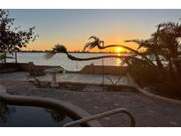 Waterfront view from a home, showcasing the serene sunset reflecting on the water and nearby cityscape at 1844 Venetian Point Dr, Clearwater, FL 33755
