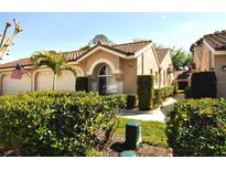 Charming one-story home with a red tile roof, lush landscaping, and an inviting arched entryway, showcasing curb appeal at 3876 Darston St, Palm Harbor, FL 34685