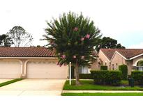 Charming single Gathering home with a tile roof, beautiful landscaping, and an attached two-car garage at 3876 Darston St, Palm Harbor, FL 34685