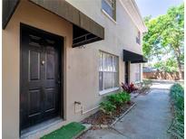 Charming exterior with a classic black door and awning, complemented by neat landscaping at 408 S Arrawana Ave # B4, Tampa, FL 33609