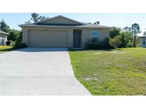 Single-story home featuring an attached garage, a simple lawn, and neutral-toned exterior at 6422 Towhlen Rd, North Port, FL 34291