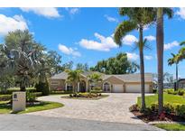 Beautiful single-story home with a circular brick driveway and lush tropical landscaping at 10905 Elliot St, Riverview, FL 33578