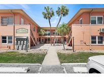 Charming condo complex exterior with lush landscaping, palm trees, and well-maintained grounds in a sunny setting at 121 46Th Ave # 2H, St Pete Beach, FL 33706