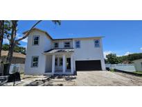 Charming two-story home featuring a modern design, attached garage, and framed by a clear blue sky at 1405 50Th N Ave, St Petersburg, FL 33703