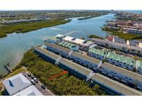 Aerial view of a waterfront condo community with lush green landscaping and beautiful water views at 19823 Gulf Blvd # 33, Indian Shores, FL 33785