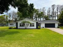 Charming single-story home featuring a well-manicured lawn and dark accents at 210 Lake Hobbs Rd, Lutz, FL 33548