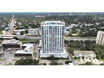 Stunning aerial view of modern high-rise condo building with pool, overlooking the city and a lush tree canopy at 2910 W Barcelona St # 403, Tampa, FL 33629