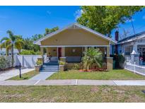 Charming bungalow featuring a quaint front porch, red door and established landscaping with a sidewalk leading to the street at 3504 N 12Th St, Tampa, FL 33605