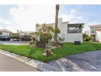 A two-story home with a lush green lawn and mature trees and the parking area at 4319 Harbor House Dr, Tampa, FL 33615