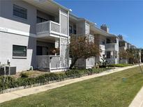Apartment building featuring white lattice balconies, manicured landscaping, and a concrete walkway at 4405 W Fair Oaks Ave # 9, Tampa, FL 33611