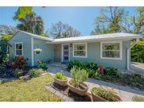 Charming single-story home featuring a well-manicured lawn and a whimsical blue front door at 604 W Hilda St, Tampa, FL 33603