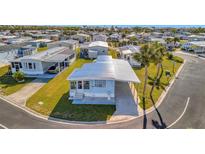 Charming blue single-story home with covered parking and well-maintained landscaping in a quiet community at 128 E Saint Johns Way, Apollo Beach, FL 33572