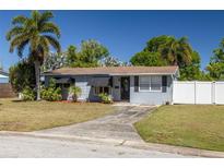 Charming single-story home with a well-manicured lawn, palm trees, and a concrete driveway leading to the entrance at 1541 68Th N Ave, St Petersburg, FL 33702